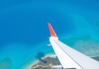 Vliegtuig dat over de turquoise wateren van Curaçao vliegt